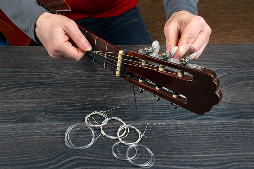 replacement and insertion of nylon strings in a classical guitar. lesson for a musician