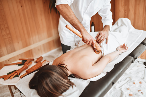 Massage With Wooden Roller in Modern Spa Center