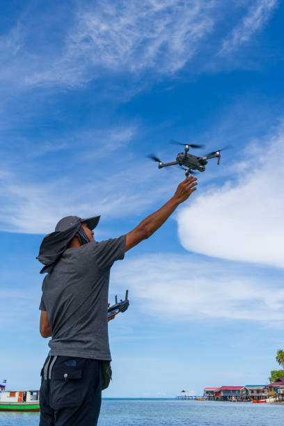Drone operator was reaching for his drone that was being landed down. stock photo