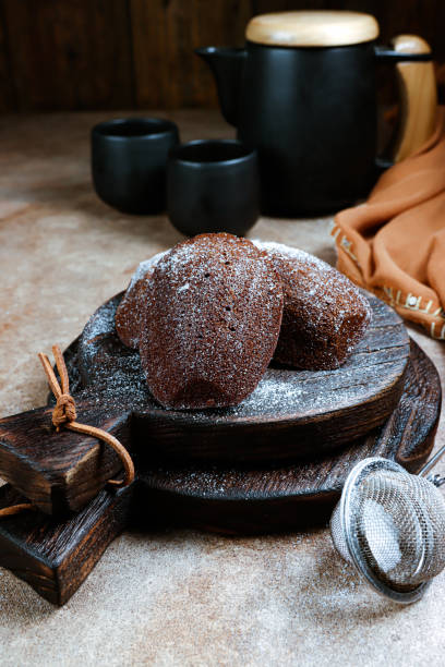 istock Kue madeleine coklat. Chocolate Madeleines cakes dusted with icing sugar 1356704460
