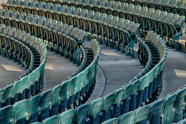 Rows of green plastic stadium seats. stock photo