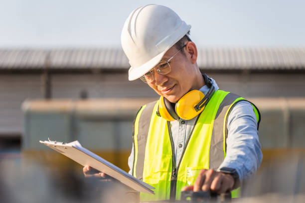 istock Engineer in waistcoats and hardhats with clipboard checklist inspecting construction site, Smiling mechanical worker checking of the battery storage system 1356710290