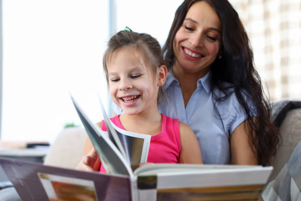 istock Mum reading book with child 1356711179