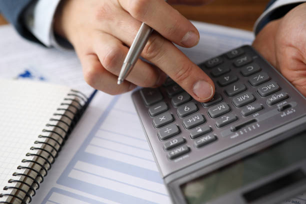 istock Man analyzes cost renting, counting on calculator 1356711185