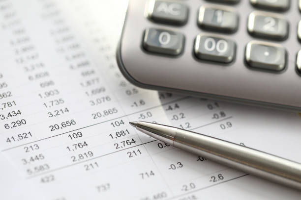 istock Silver pen lies on report with numbers, calculator 1356711209