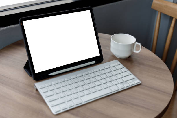 istock Blank screen laptop computer modern man use room laptop with blank white desktop screen with coffee cup on wooden table in cafe 1356714393