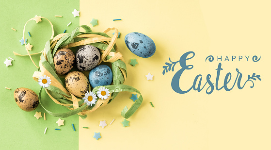 Easter eggs in the stylish nest and Happy Easter hand lettering inscription on yellow green background.