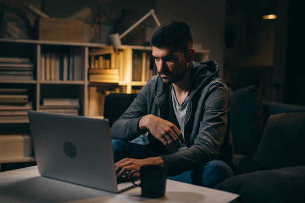 istock man working on laptop late night at home 1356717425