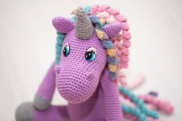 istock A knitted unicorn with a multicolored mane. A toy for a child. 1356719517