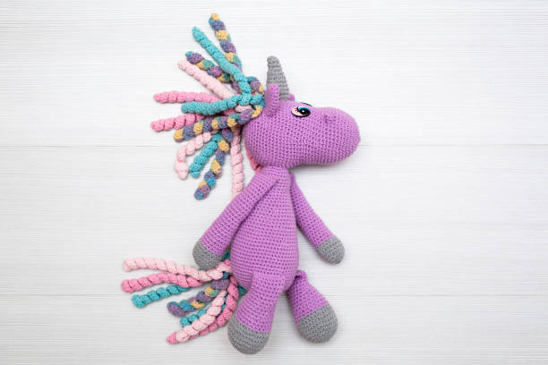 istock A knitted unicorn with a multicolored mane. A toy for a child. 1356719520