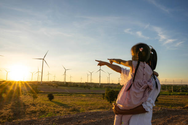 Wind turbines are alternative electricity sources, the concept of sustainable resources, People in the community with wind generators turbines, Renewable energy stock photo
