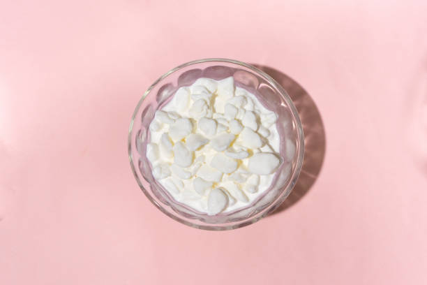 istock Cottage cheese in a glass container on a pink background 1356727854