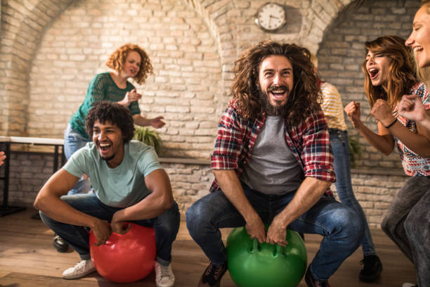 istock Cheerful colleagues having fun during space hopper at casual office. 1356727897