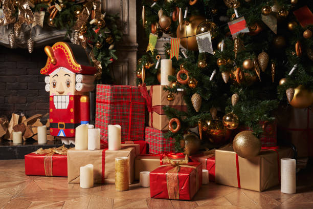 istock gifts in beautiful boxes under the Christmas tree and a nutcracker by the fireplace 1356730004