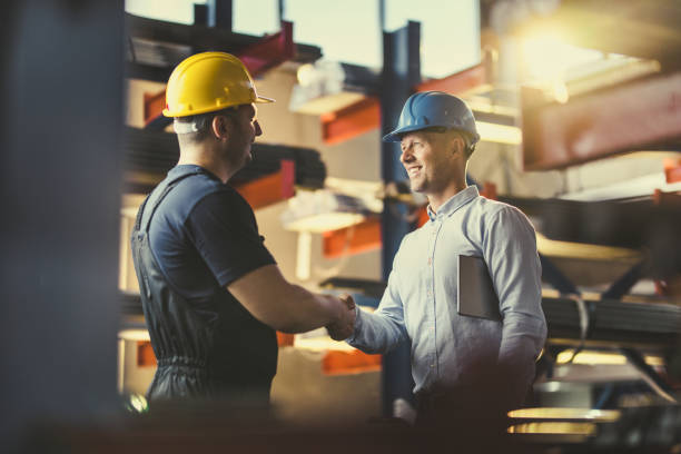istock Happy manager shaking hands with manual worker in aluminum mill. 1356730410