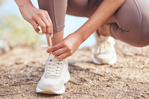 Closeup shot of an unrecognisable woman tying her shoelaces while exercising outdoors I woke up early with determination lace fastener photos stock pictures, royalty-free photos & images