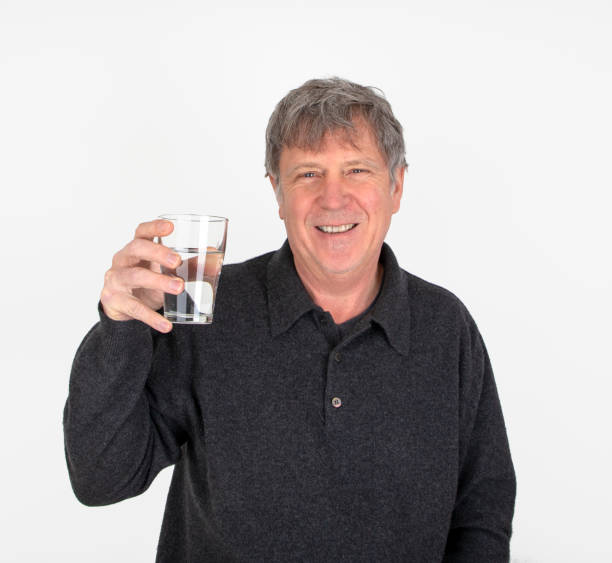 istock positive looking man is drinking water out of a  glass 1356733763