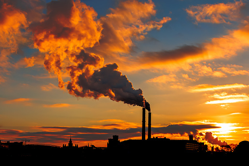 beautiful sunset over Factory chimneys smoke industrial building silhouette. Environmental problem of environmental and atmospheric pollution.Climate change,environmental disaster. smoky toxic substances