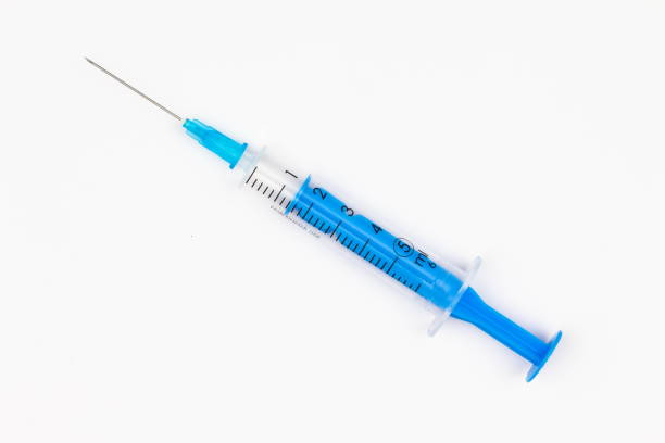 seringa descartável azul para injeção em um fundo branco. instrumento médico para vacinação. 5 ml de seringa para vacina covid-19. equipamento médico. isolado. vista superior. close-up - injeção - fotografias e filmes do acervo
