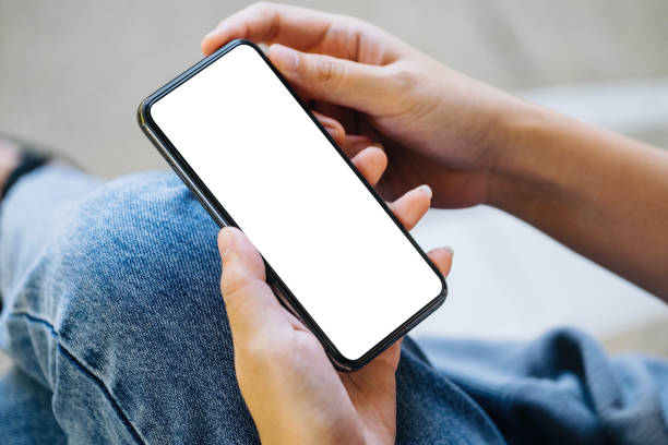 istock A woman holding a cell phone with a blank white screen. The blank space on the white screen can be used to write a message or place an image. 1356740108