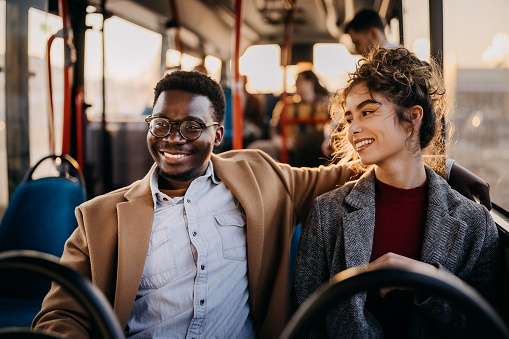 Young couple on a city bus having a conversation
