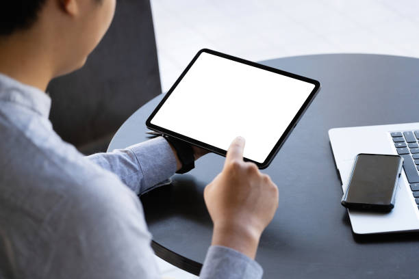 istock A man holding a tablet with a blank white screen. The blank space on the white screen can be used to write a message or place an image. 1356740855