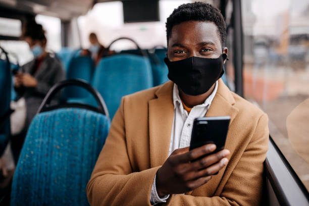 istock Young handsome man posing with face mask in public bus 1356740967