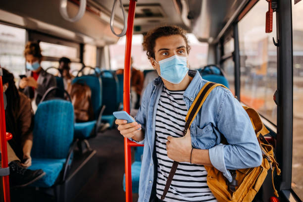istock Young man with protective face mask in public bus 1356741438