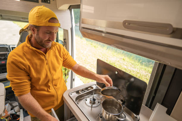 istock Living the van life, young man inside camper van cooking 1356743541
