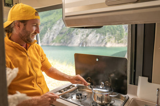 istock Living the van life, young man inside camper van cooking 1356743578
