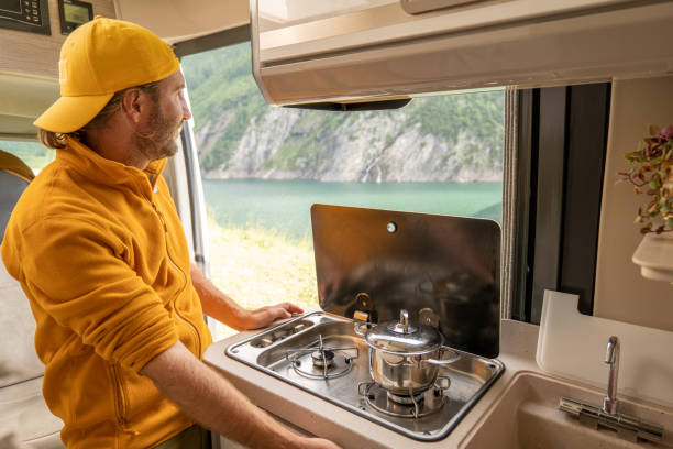 istock Living the van life, young man inside camper van cooking 1356743587