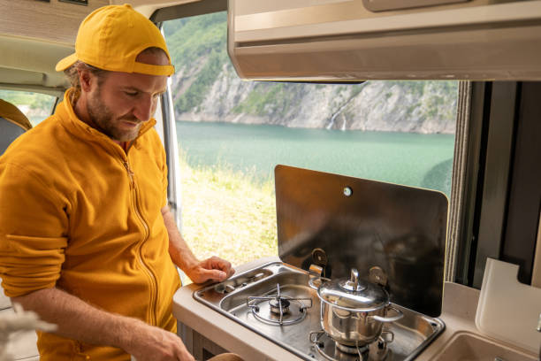 istock Living the van life, young man inside camper van cooking 1356743619