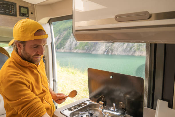 istock Living the van life, young man inside camper van cooking 1356743622