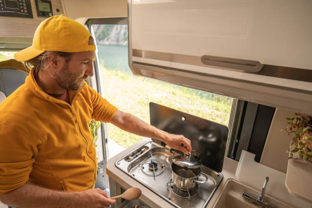istock Living the van life, young man inside camper van cooking 1356743642
