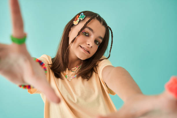 istock Girl wearing creative accessorizes stretching hands to the camera and smiling 1356744699