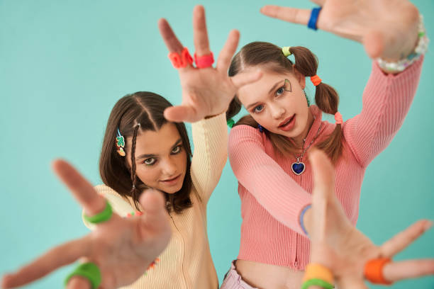 istock Girls stretching hands to the camera while posing at bright and creative clothes 1356744745
