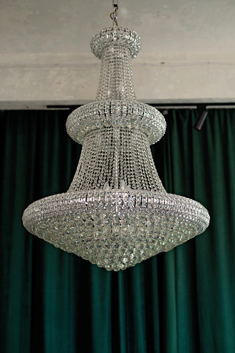 Large antique crystal chandelier in loft style interior. Soft side-by-side focus.