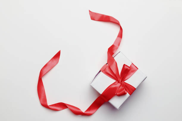 istock White gift box with red ribbon, isolated on white background 1356747647