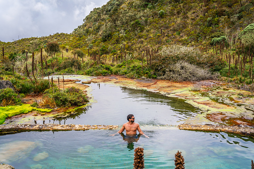 Young man swimming in hot springs water in  Colombia