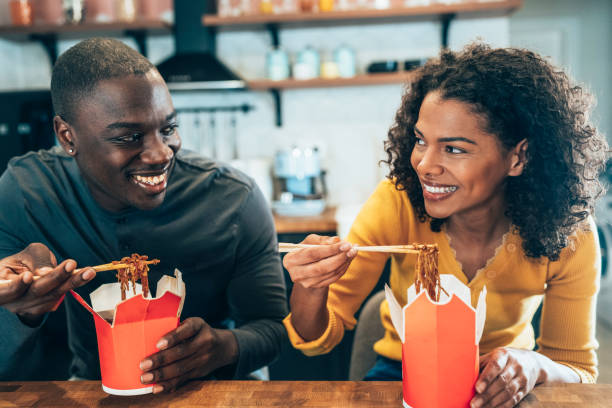 Take away food at home Afro-american Couple eating take-out Chinese food at home chinese food stock pictures, royalty-free photos & images