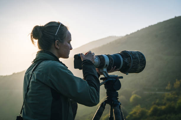 młoda kobieta obserwuje odległą scenę nad górami, z drzwi - lens camera focus photography zdjęcia i obrazy z banku zdjęć