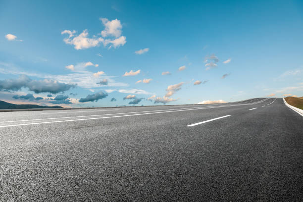 istock Asphalt road and mountains under blue sky 1356757179