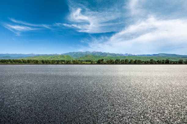 istock Asphalt road and green mountains under blue sky 1356757558