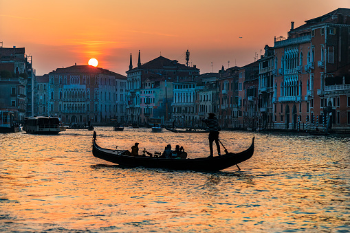 Gondoliers at Sunset on Grand Canal in Venice , Italy