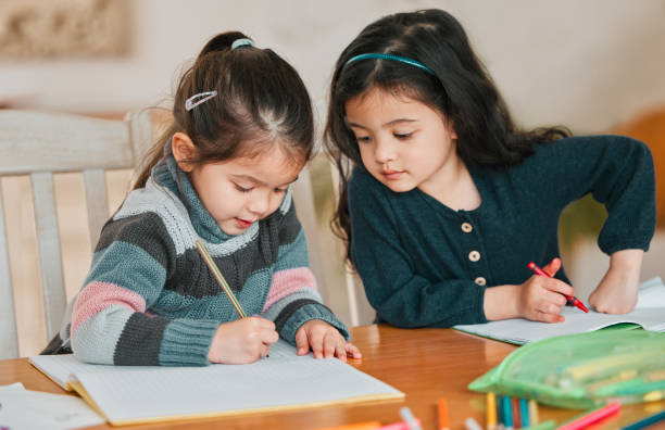 istock Shot of two sisters completing their homework together 1356759608