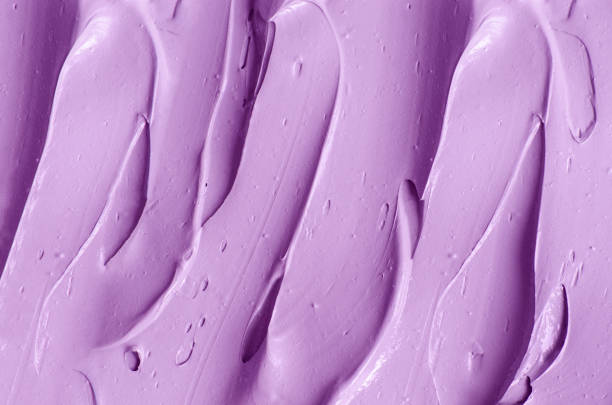 istock Purple clay (alginate face mask, body wrap, hair shampoo, conditioner) texture close up, selective focus. Abstract lavender background with brush storkes. 1356759857