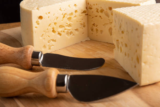 istock Semi-cured cheese from Brazil, beautiful Brazilian cheeses and cutting accessories arranged on light rustic wood, selective focus. 1356760310