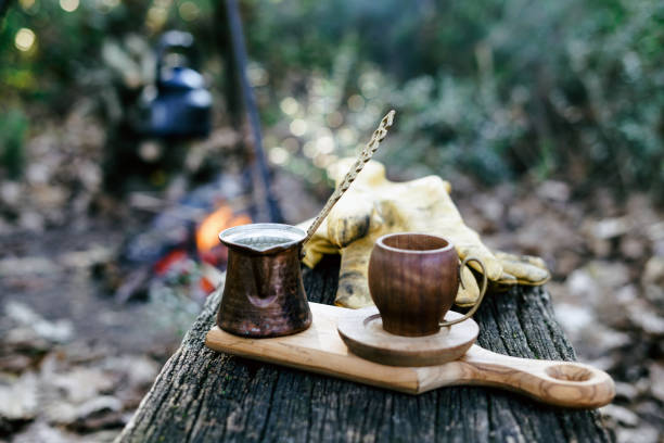 istock Boiling coffee in turkish cezva on campfire coals. Luxury camping concept. 1356762564