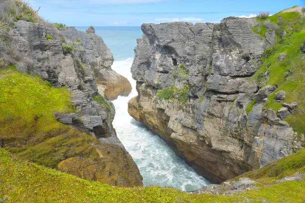 Pancake rocks in Punakaiki, New Zealand. The Pancake Rocks at Dolomite Point near Punakaiki are a heavily eroded limestone area where the sea bursts through several vertical blowholes