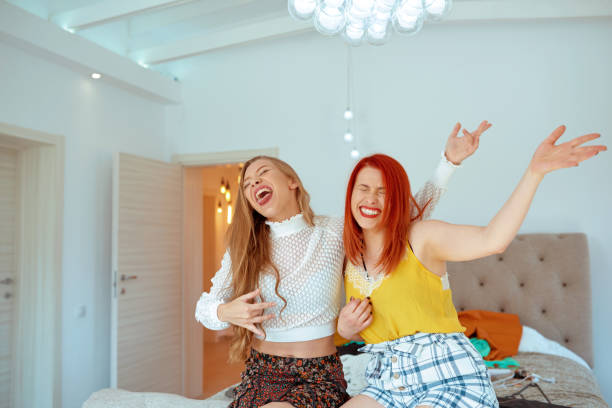 Women playing the air guitar Two women, redhead and blond, playing the air guitar feeling happy dancing and singing air guitar stock pictures, royalty-free photos & images